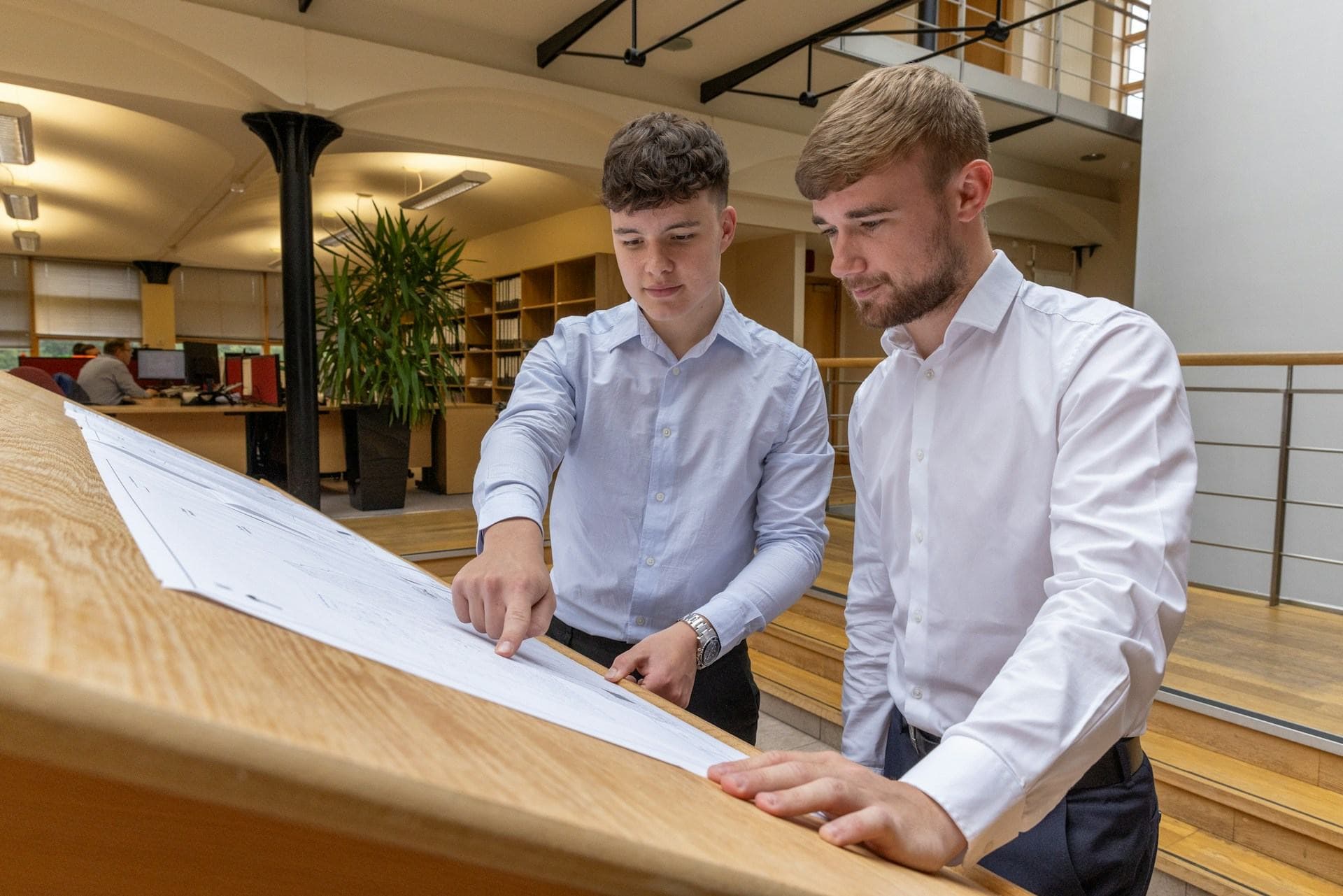 Professionals review a plan at a meeting table